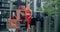 Young woman in red performs callisthenics with ribbon in the libing apartment yard, gymnast does acrobatic exercises in