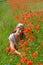 The young woman among red poppies