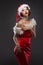 young woman in a red skirt and santa claus hat on a light background celebrates christmas