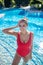 Young woman in red swimsuit standing in pool water
