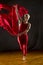 Young woman in red unitard swirling red fabric in studio.