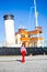 Young woman in red walking over big vintage yacht in port