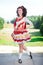 Young woman in red and white irish dance dress and wig posing