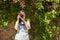 A young woman with reddish hair takes photographs with her camera next to a wall covered with bougainvillea Caceres