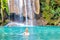 Young woman relaxes in emerald blue lake, Erawan National park, Thailand