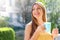 Young woman relaxing on balcony holding mug of cappuccino or tea at home in the morning