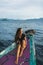 Young woman relaxing on boat at sunset in ocean