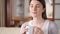 Young woman relaxing on couch at home. Pretty female drinking coffee or tea from cup in living room