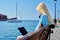 Young woman relaxing in headphones with a laptop on the seashore