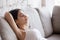 Young woman relaxing leaning back on comfortable sofa