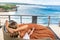 Young woman relaxing in lounge on veranda with sea view