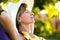 Young woman relaxing outdoors on sunny summer day. Happy lady lying down on comfortable beach chair daydreaming thinking. Calm