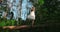 Young woman relaxing outdoors in the wood, she do tree position. Woman balanced on one leg on a fallen tree. In harmony