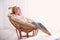 Young woman relaxing in papasan chair near window