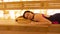 Young woman is relaxing in a warm sauna with Himalayan salt, lying on a wooden shelf with her eyes closed