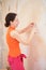 Young woman remove old wallpapers