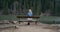 Young woman rest on bench at gulf shore. Long hair fly on cool wind . On the shore of the lake. 4k .Beautiful place.