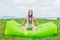 Young woman resting on an air sofa in the park.