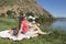 Young woman resting on bank of a the lake is