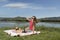 Young woman resting on bank of a the lake is