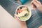 Young woman is resting and eating a healthy oatmeal after a workout.