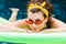 young woman resting on inflatable mattresses and looking at camera in swimming