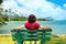 Young woman resting on park bench along Hawaiian ocean