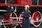 Young woman in retro styled clothes standing by vintage steam train