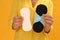 Young woman with reusable menstrual pad and pantyliner on yellow background, closeup