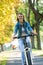 Young woman ride bike in autumn park. Enjoying while cycling in nature during autumn day