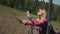 Young woman rides on the mountain lift, Makes selfie using smartphone and Selfiestick. background of the forest in