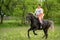 Young woman riding on beautiful horse , having fun in summer time , Romania countryside