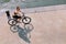 Young woman riding a bike on the stone embankment of the river