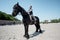 Young woman riding brown purebred horse