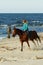 Young woman riding horse on the beach.