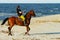 Young woman riding horse on the beach.