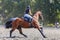 Young woman riding horse on equestrian competition