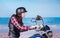 Young Woman Riding Motorcycle Past Beach