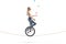 Young woman riding a unicycle on a rope and juggling with balls