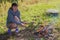 Young woman is roasting sausages over a fire in the mountains, A