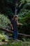 Young woman after a rock climb watching and exploring waterfall in Wicklow Mountains in sunny day, Wicklow Mountains, Ireland