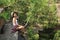 Young woman on rocky mountain in forest