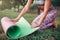 Young woman rolling yoga mat in park