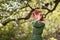 Young woman in romantic green dress in a blooming apple garden.