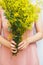 Young woman in a rosy dress holding a bunch of colorful picked w