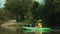 A young woman is rowing a kayak on the river. Back view. Real time. Soft focus. The concept of active recreation and