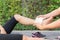 Young woman runner ankle being applied bandage by man in park. i