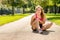 Young woman runner touching knee in pain outdoors