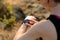 Young Woman Runner Using Multisport Smartwatch at Sunset Trail. Closeup of Hand with Fitness Tracker. Sports Concept