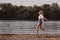 A young woman running freedom against the background of the river and trees. Profile photo a beautiful happy blonde in